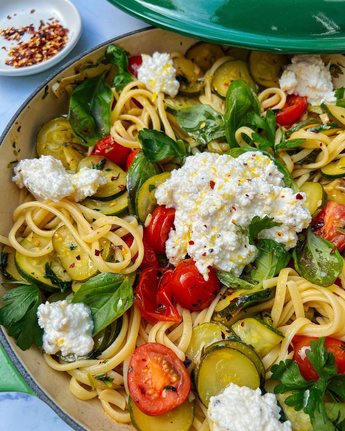 Zucchini & tomato pasta, topped with a zesty ricotta.